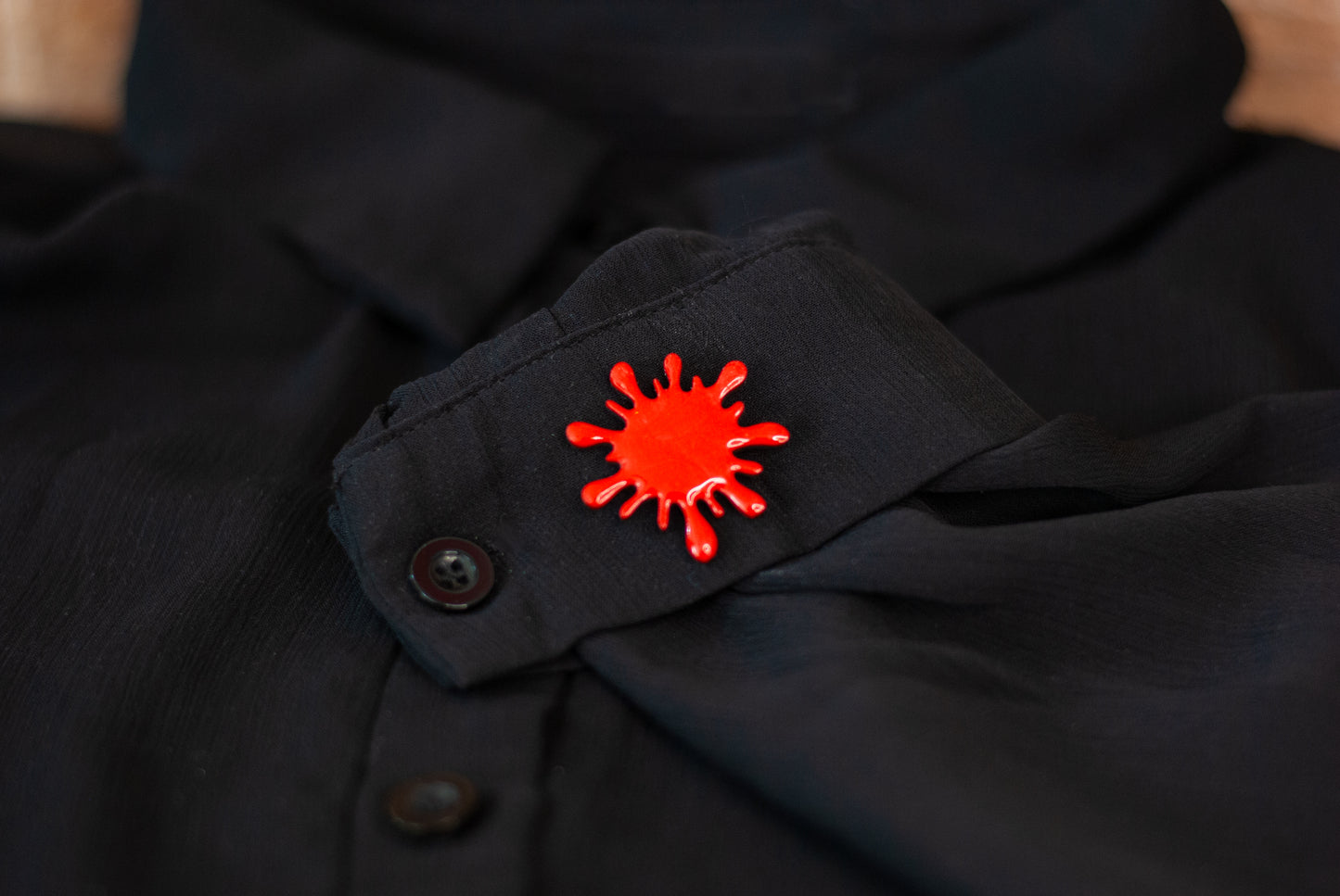 Blood red splatter brooch pin on black sheer shirt