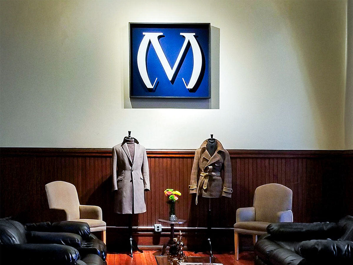 custom made business sign for bespoke suit brand hanging on wall of shop