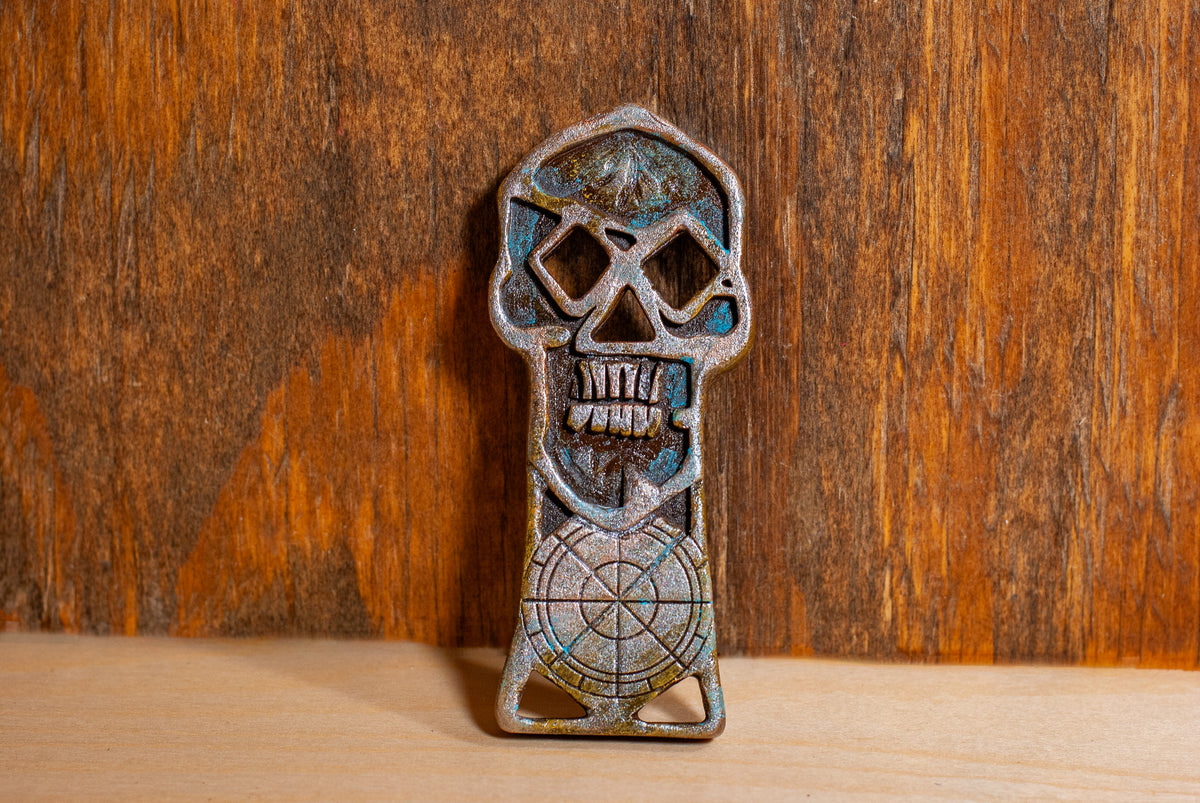 A copper bones skeleton key prop in front of a wooden background