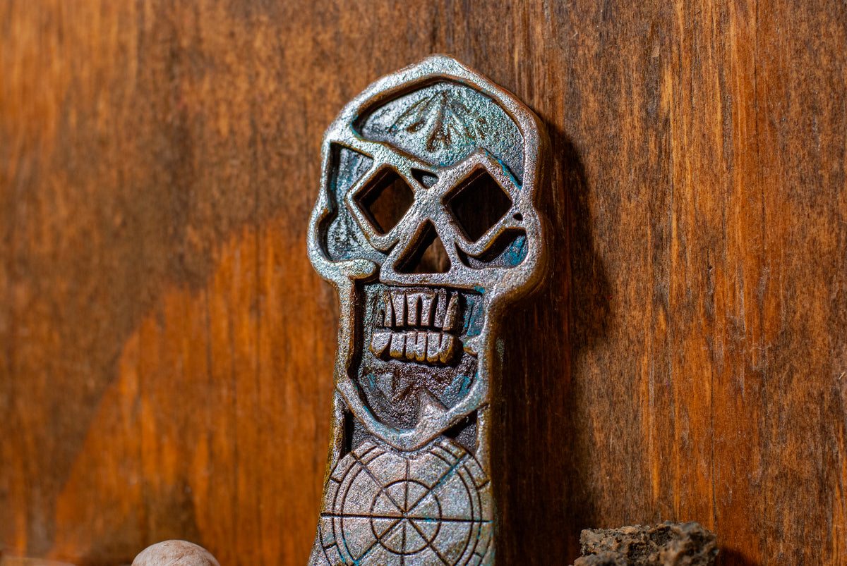 Close up view of a copper bones skeleton key prop on a wooden surface.