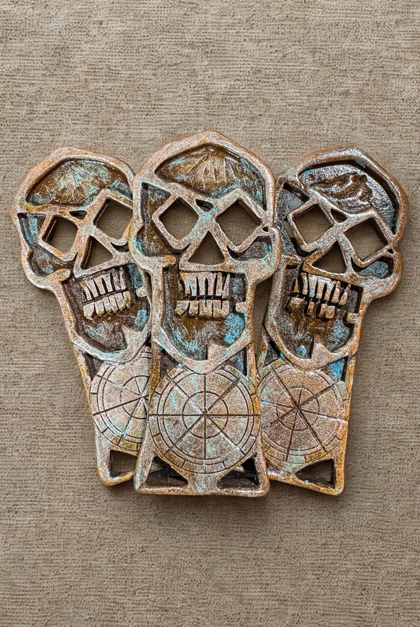 Three copper bones skeleton key props on a burlap fabric surface.