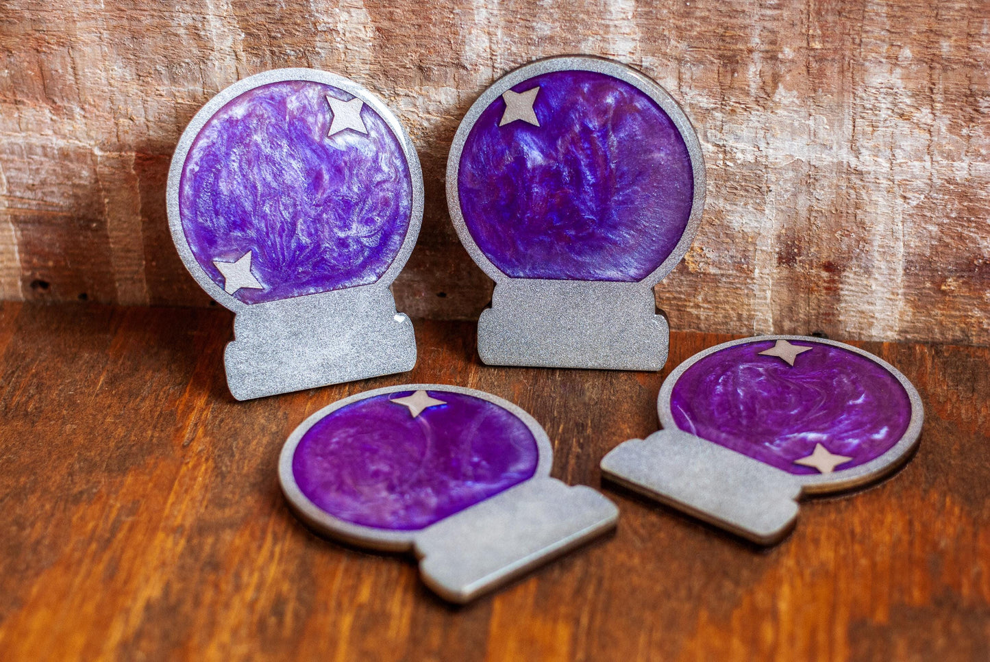 Four purple crystal ball-shaped coasters on a wooden tabletop