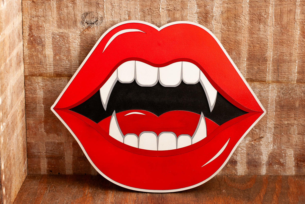 wooden wall art of blood red lips with vampire fangs on a wooden background