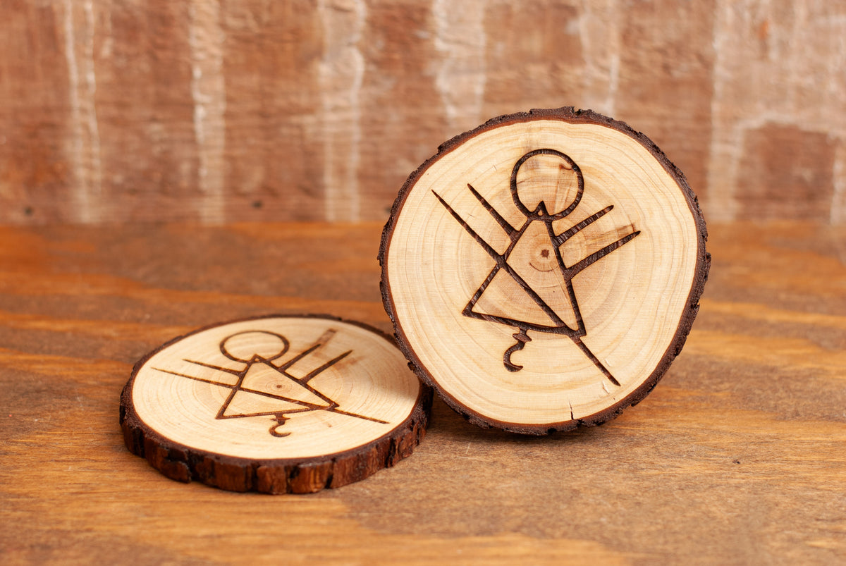 Two wooden coasters with engraved rune symbols on a wooden surface