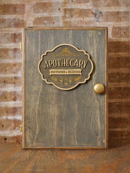 rustic wooden apothecary-style box with bronze and gold accents with 'Apothecary Potions Elixirs' label on a wooden background