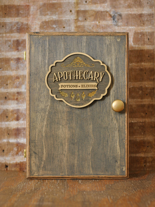 rustic wooden apothecary-style box with bronze and gold accents with 'Apothecary Potions Elixirs' label on a wooden background