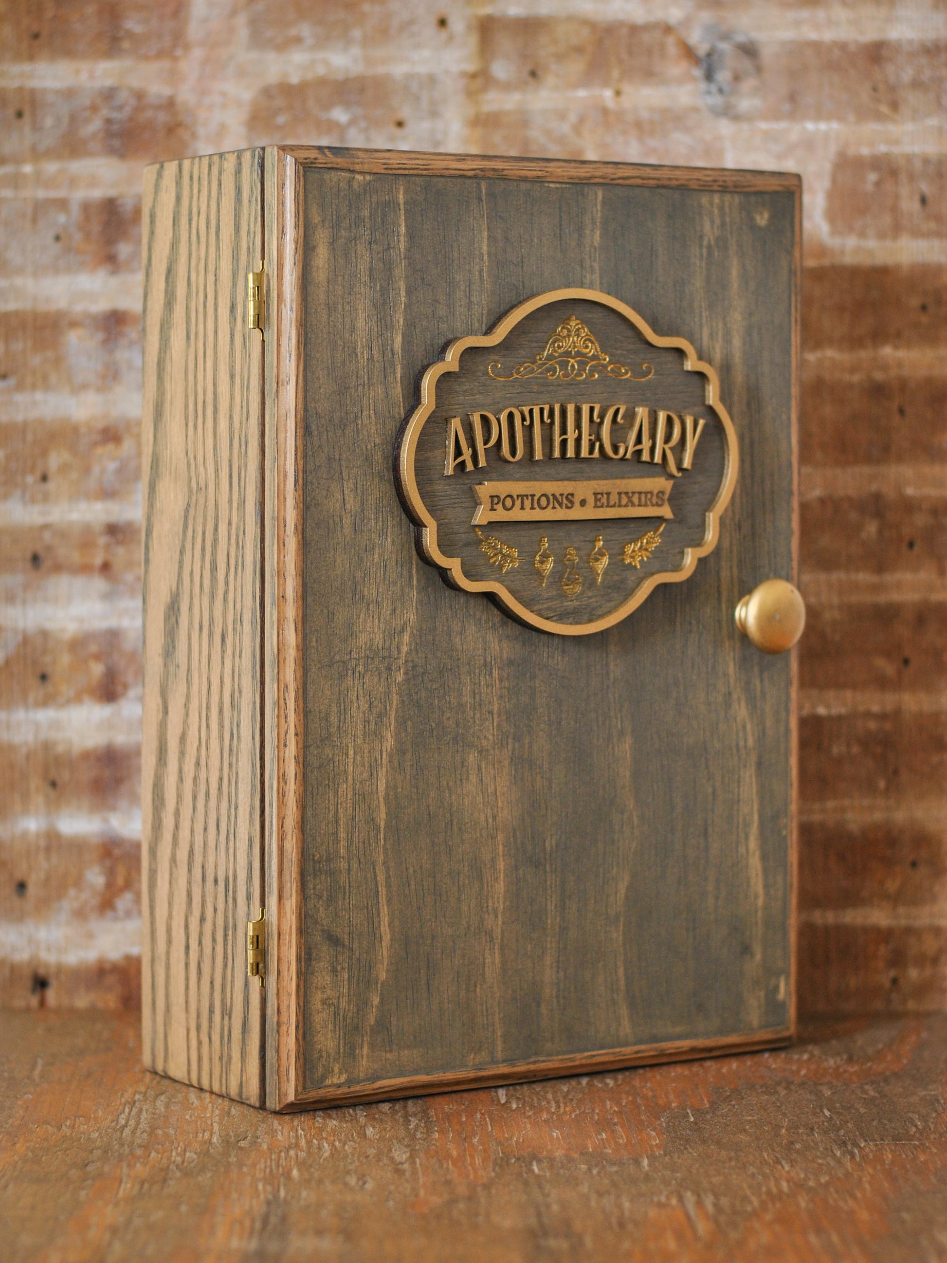 rustic wooden apothecary-style box with bronze and gold accents with 'Apothecary Potions Elixirs' label on a wooden tabletop and brick background