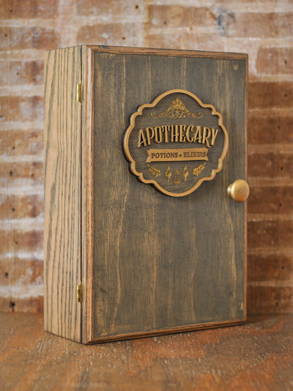 rustic wooden apothecary-style box with bronze and gold accents with 'Apothecary Potions Elixirs' label on a wooden tabletop and brick background