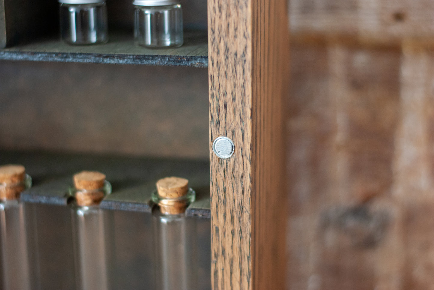 close-up of glass vials with cork tops and jars in various sizes in a rustic  wooden apothecary box with a magnetic fastening