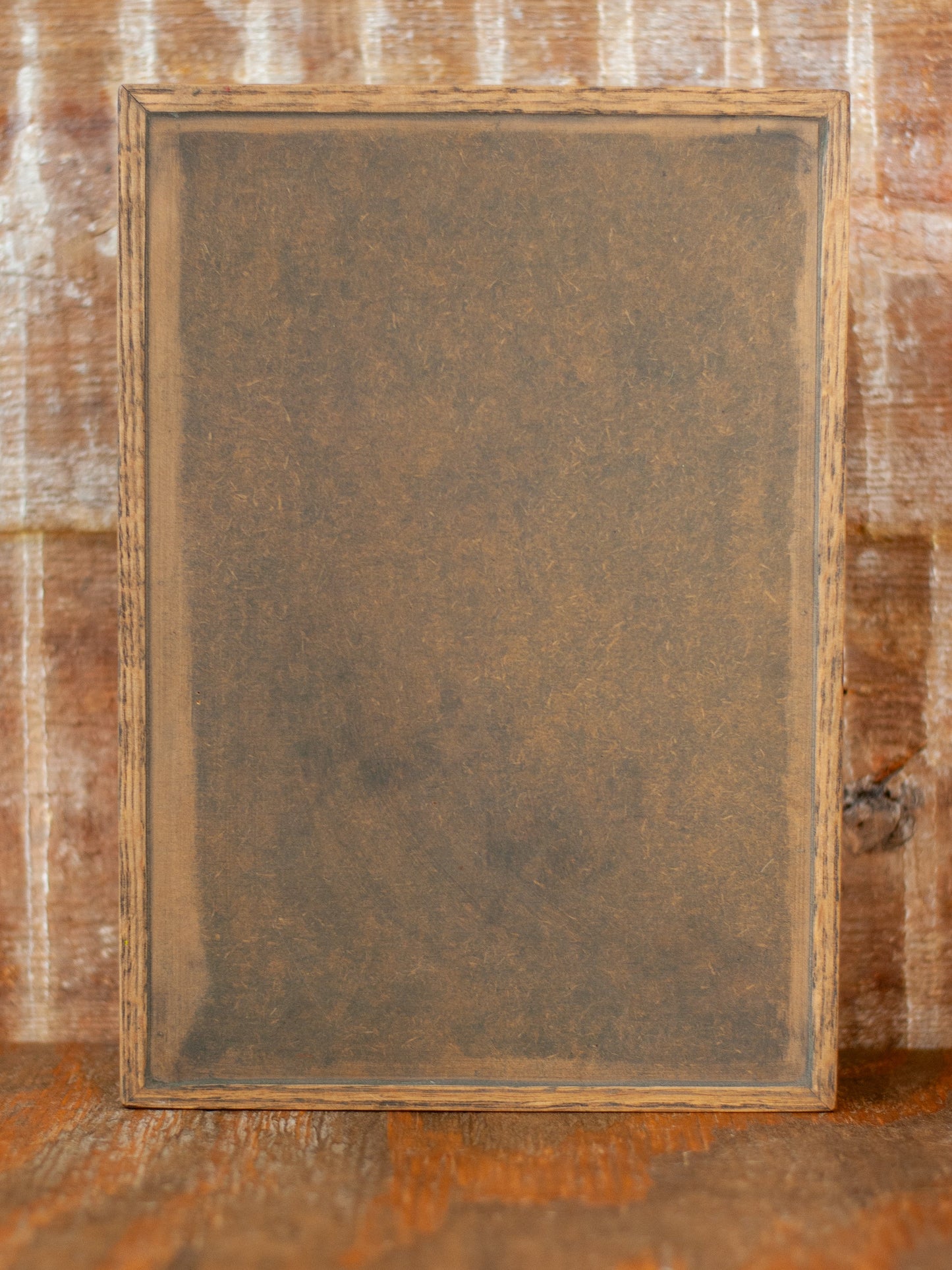 Back view of rustic wooden apothecary box against a bruck background and wooden tabletop