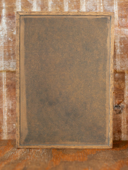 Back view of rustic wooden apothecary box against a bruck background and wooden tabletop