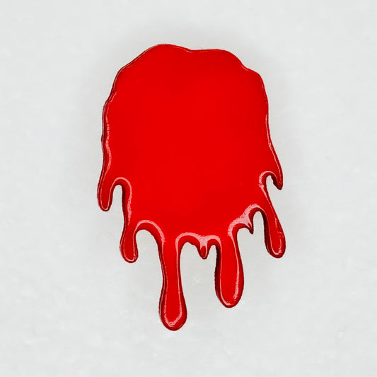 Close up view of red blood dripping designed pin for backpack, shirt, or bag on a white background