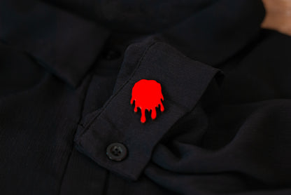 Red blood drop pinback style button on a black shirt