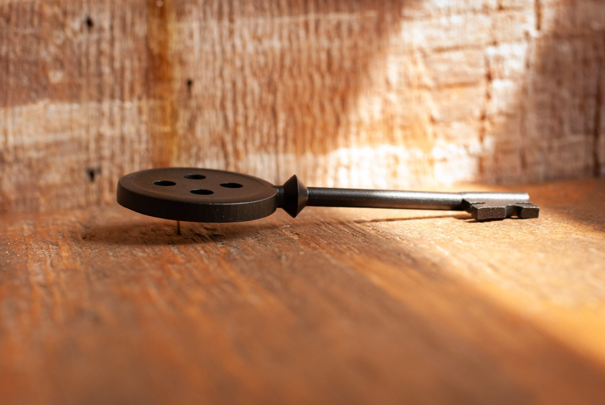Black Coraline inspired button key prop replica laying on wooden table