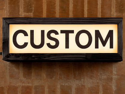 black wooden custom LED lightbox sign hanging on the wall of a recording studio