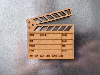 close up view of a brown engraved wood clapboard magnet on a metal fridge