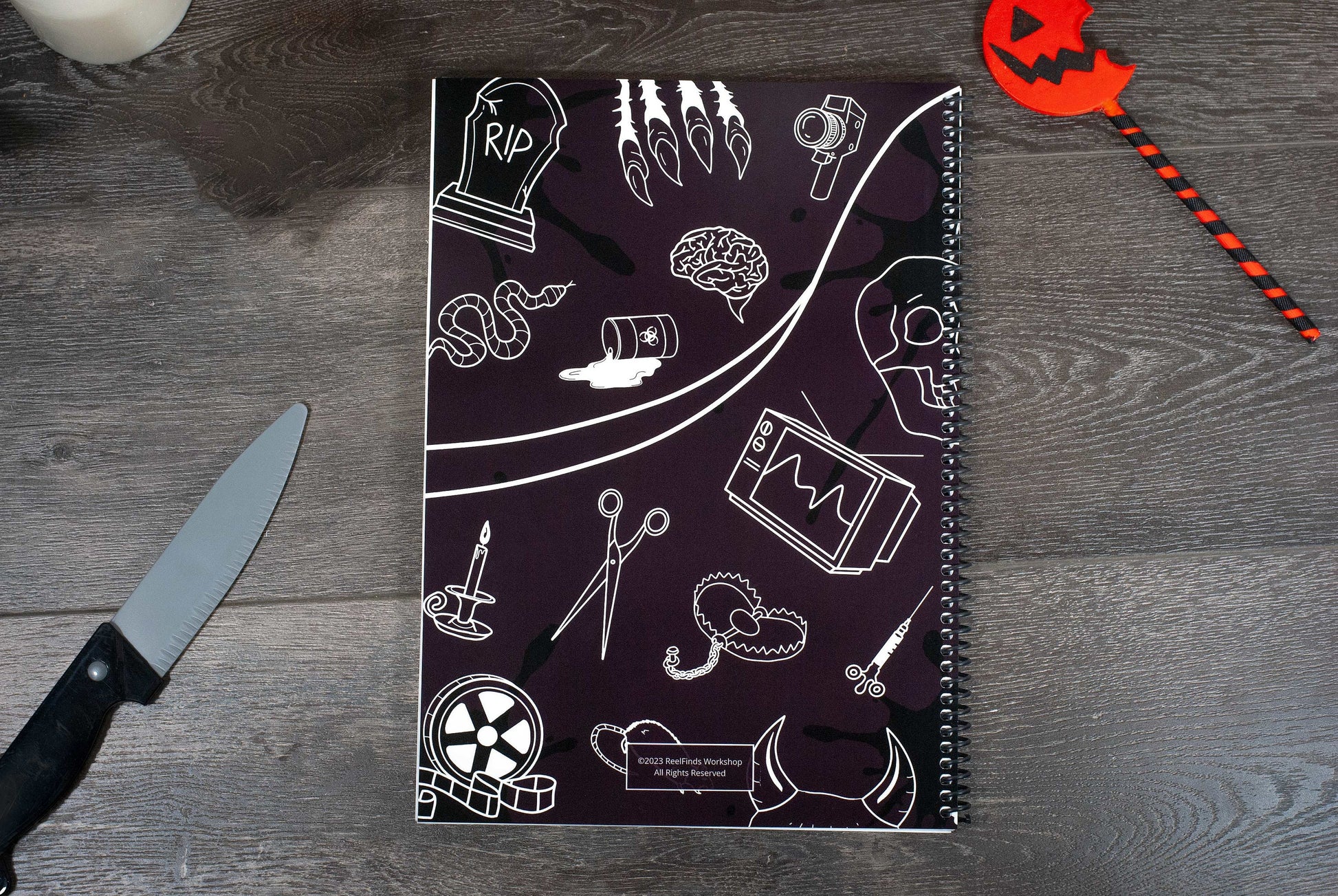 back cover of the Horror Movies Recap Book a horror movie review journal on a wooden table with halloween decorations
