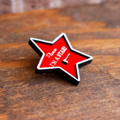 close up view of wooden please, I'm a star red brooch pin on bag, pearl horror movie inspired pin, gift for horror movie fans