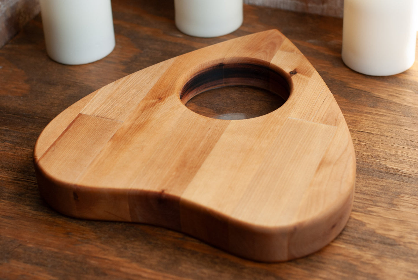 Wooden planchette shaped cutting board on a wooden surface