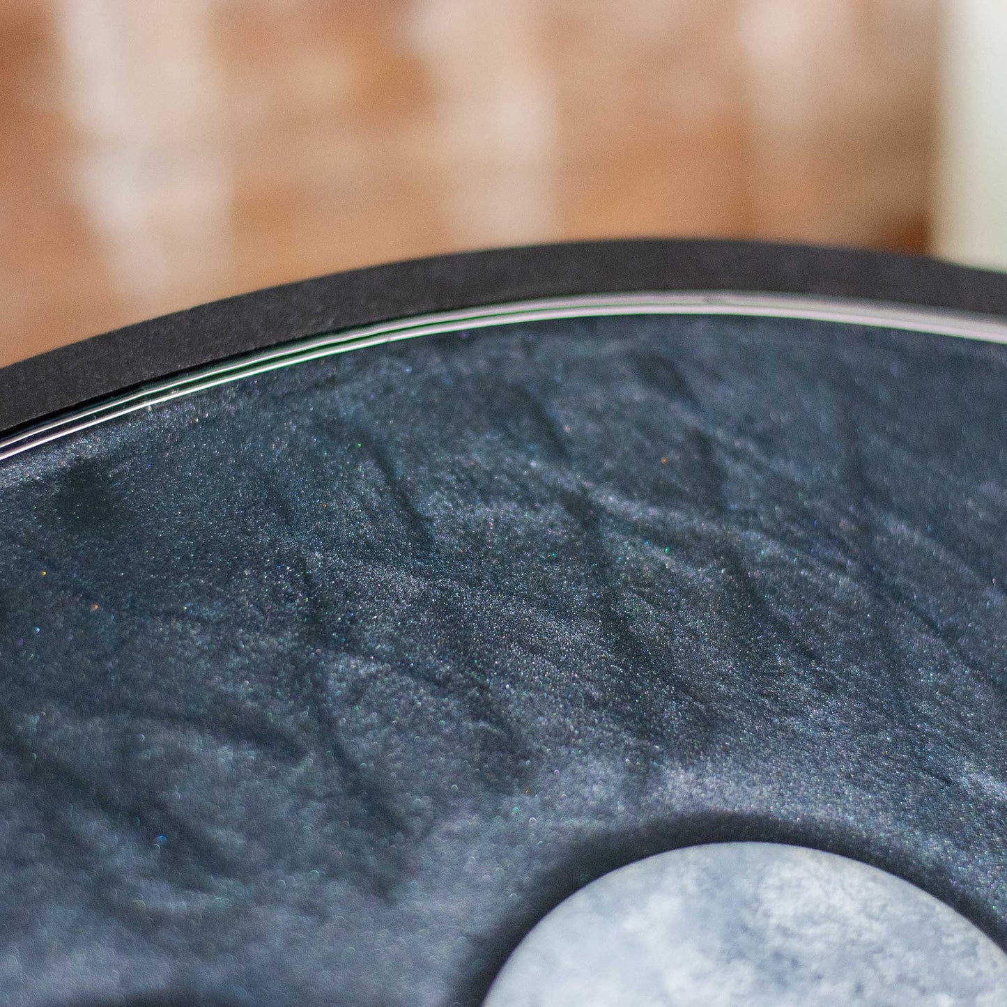 Detailed view of decorative shimmery black wooden and resin tray with moon phases on a wooden surface
