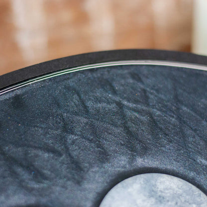 Detailed view of decorative shimmery black wooden and resin tray with moon phases on a wooden surface