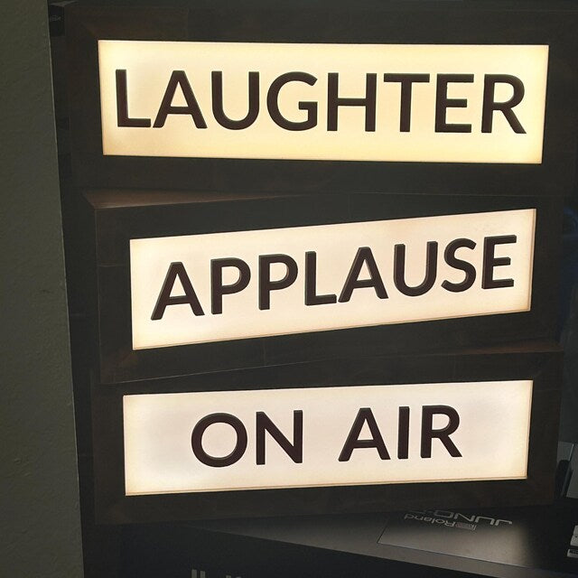 three custom theater and studio lightbox signs that read laughter, applause, on air lit up