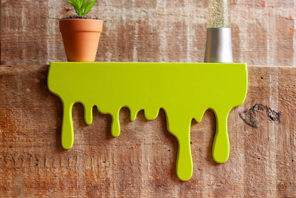 Front view of a floating green Slime Drip Shelf decor sitting on a wooden shelf, 90s Nostalgic shelf sitter, displaying Spooky Season vibes, an Accessory for Bookshelf, Display Shelf, or Mantel, Goosebumps inspired decor