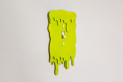 Green slime drip light switch cover plate with a unique design on a white background