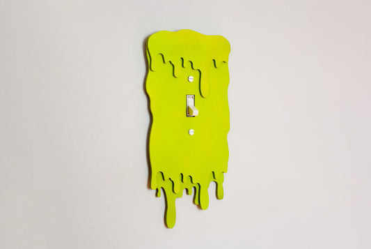 Green slime drip light switch cover plate with a unique design on a white background