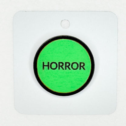 green retro-style vintage VHS horror label pin on white backing card with white background