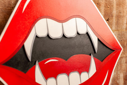 gothic wall art red lips with fangs on a wooden background